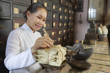 在中國(guó)傳統(tǒng)藥店工作的老年婦女和配重包