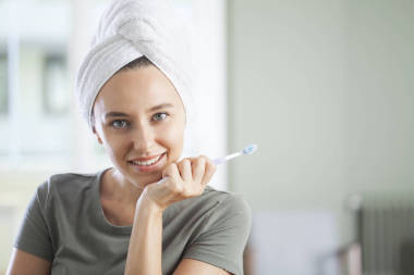 一個(gè)笑著拿著牙刷的可愛(ài)女人的畫像 