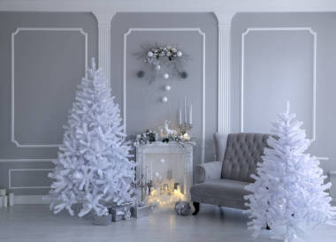 白色背景的圣誕裝飾品。 螢火蟲、蠟燭和巨大的白色圣誕樹