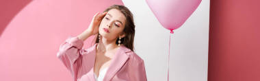 迷人的年輕女子拿著粉色和白色氣球的全景照 