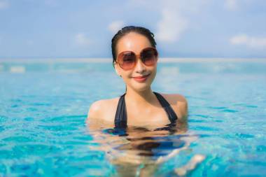 美麗動(dòng)人的年輕亞洲女人快樂的微笑放松戶外的