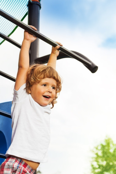 在单杠上的小男孩图片