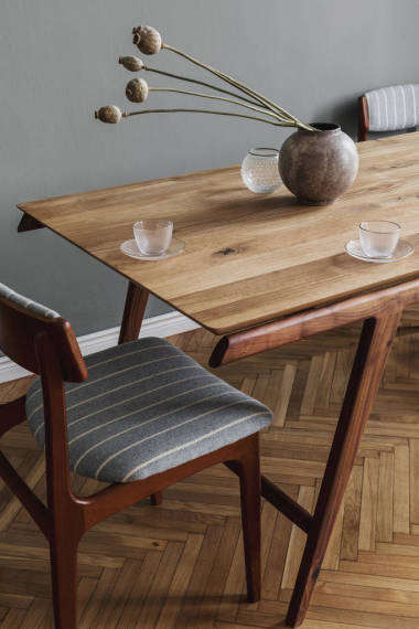 時(shí)尚而現(xiàn)代的餐廳內(nèi)部有設(shè)計(jì)木制餐桌、椅子、華麗的裝飾和典雅的配飾。 花瓶里的花 模板。 室內(nèi)設(shè)計(jì)。 家居裝飾. 