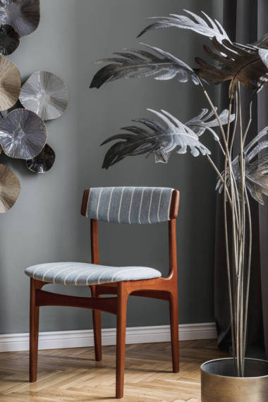 时尚而现代的餐厅内部有设计木制餐桌、椅子、华丽的装饰和典雅的配饰。 花瓶里的花 模板。 室内设计。 家居装饰. 