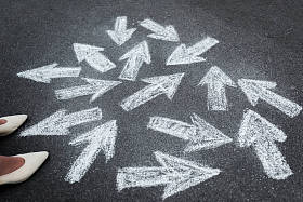 妇女站在沥青路面上的近向箭头的剪影 