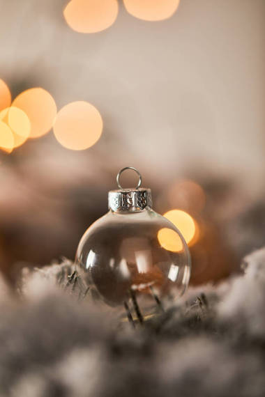 在雪地里的云杉樹枝上掛著透明的圣誕球，燈亮
