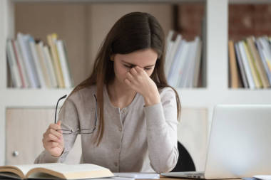 超載的年輕女孩感到疲勞，摘下眼鏡