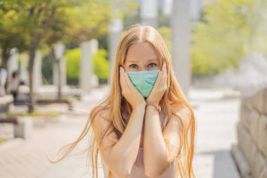 在戶外佩戴面部衛(wèi)生防護(hù)面具的女性。 戴口罩的人因為灰塵太濃 在世界主要城市發(fā)現(xiàn)的問題。 空氣污染、環(huán)保意識概念