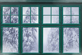 窗外的窗框，外面有白雪覆盖的冷杉树 