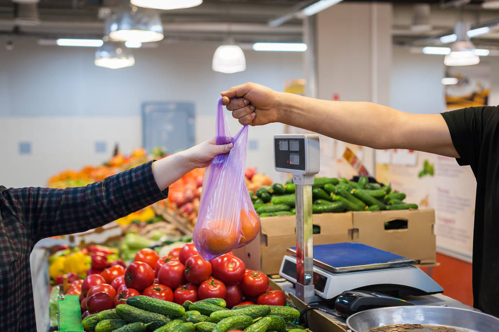 女人买新鲜的蔬菜,在街头市场 女人买新鲜的蔬菜,在街头市场