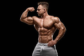 肌肉男子显示肌肉孤立在黑色背景。强壮的男性裸体躯干腹