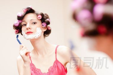 美麗有趣的女孩與泡沫和剃刀剃她的臉
