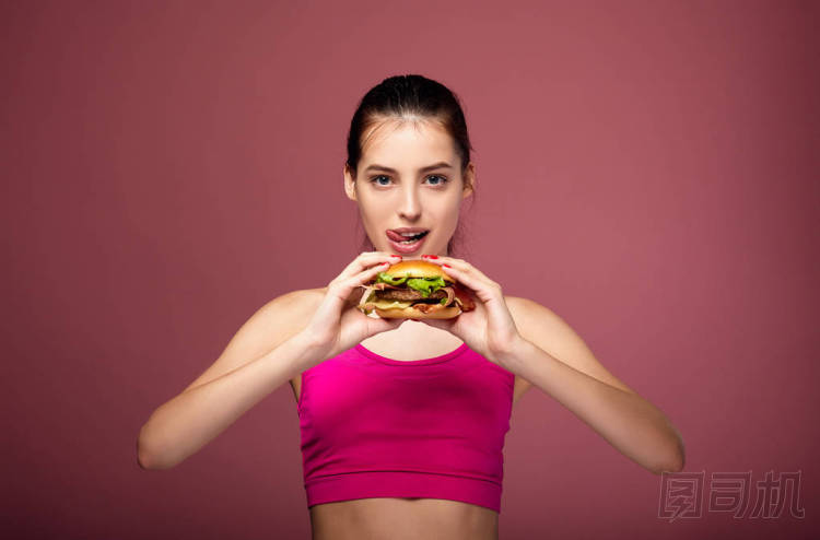 身材健美的白人女孩吃著漢堡