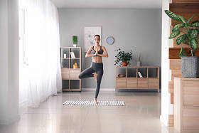 美丽的年轻女子，练瑜伽在家