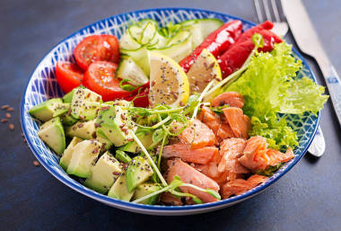 健康烤鮭魚鱷梨番茄黃瓜辣椒和奇亞籽藍(lán)色碗里的均衡午餐佛碗