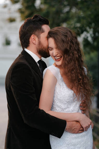 美丽的新婚夫妇在模糊的城市背景上拥抱