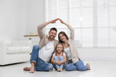 幸福的家庭手牵手在家里形成了房顶. Insura