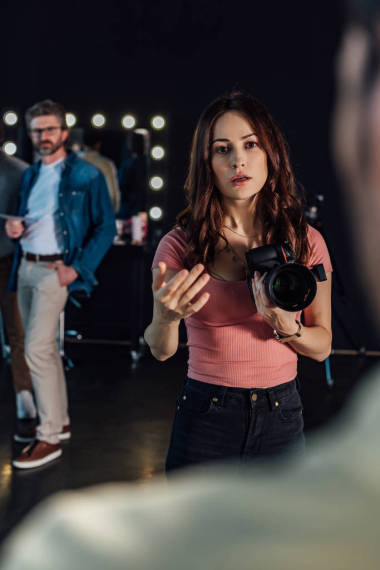 在摄影演播室为男人做手势和看男人的同时，有选择性地聚焦有吸引力的摄影师的演讲 