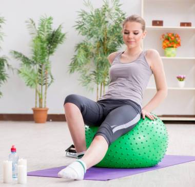 在体育馆里带着稳定球运动的年轻女子