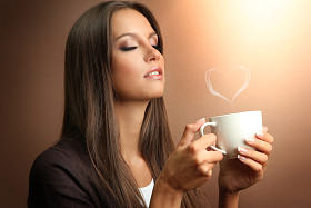 美丽的年轻女子，与杯咖啡，棕色背景上