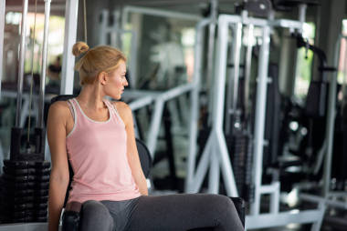 在健身俱乐部使用下拉式机锻炼的强壮女性