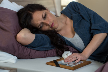 悲傷的女人正看著死去的丈夫照片