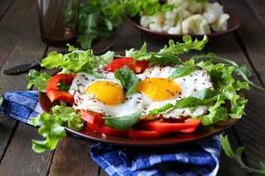 煎的雞蛋與草藥和辣椒粉的早餐