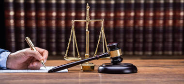 法官在法律文件在桌子上寫作圖片