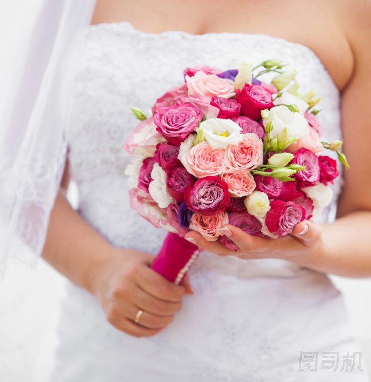 婚禮花束的玫瑰和桔梗在新娘的手