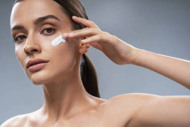 專注的女孩在灰暗的背景下護(hù)理面部皮膚