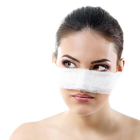 美丽年轻的女性脸，用她的鼻子上的绷带的肖像