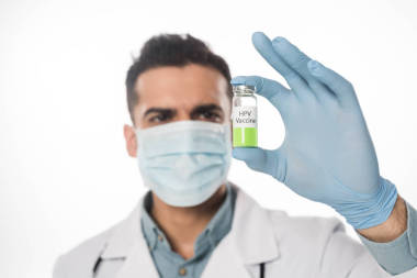 攜帶從白色分離的Hpv疫苗的醫(yī)用面罩醫(yī)生的選擇性聚焦