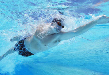 男運動員在游泳池里游泳