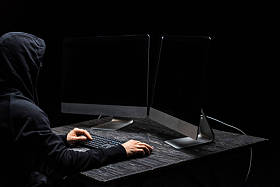 黑客使用计算机鼠标，看着计算机监视器，屏幕空白，与黑色隔离 