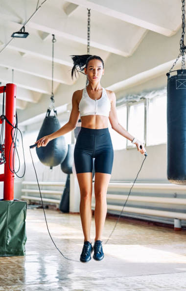 健身美女在健身房跳繩跳得漂亮.有氧運動和健身鍛煉。體育概念           
