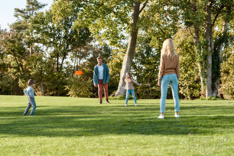 今天是周末。好好享受吧在陽光明媚的日子，父母們和孩子們在公園里玩飛盤游戲