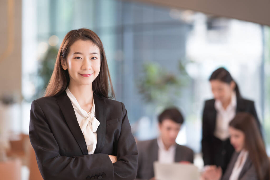 亚洲成功的女商人的画像，背景的同事