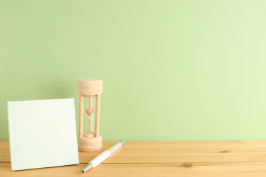 寫字臺上有沙漏和筆尖的空白便箋、工作日程和時間概念