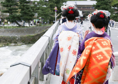 在嵐山，一座橋上行走的兩個藝妓日本