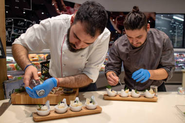  厨师们在上菜前先把开胃菜放在木盘上.厨房里的团队合作乐意效劳。有选择的重点。餐厅和精美餐厅的概念