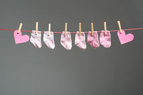 宝贝女孩袜子和纸的晾衣绳的心