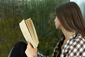 孤独悲伤的女人，透过窗户看图片