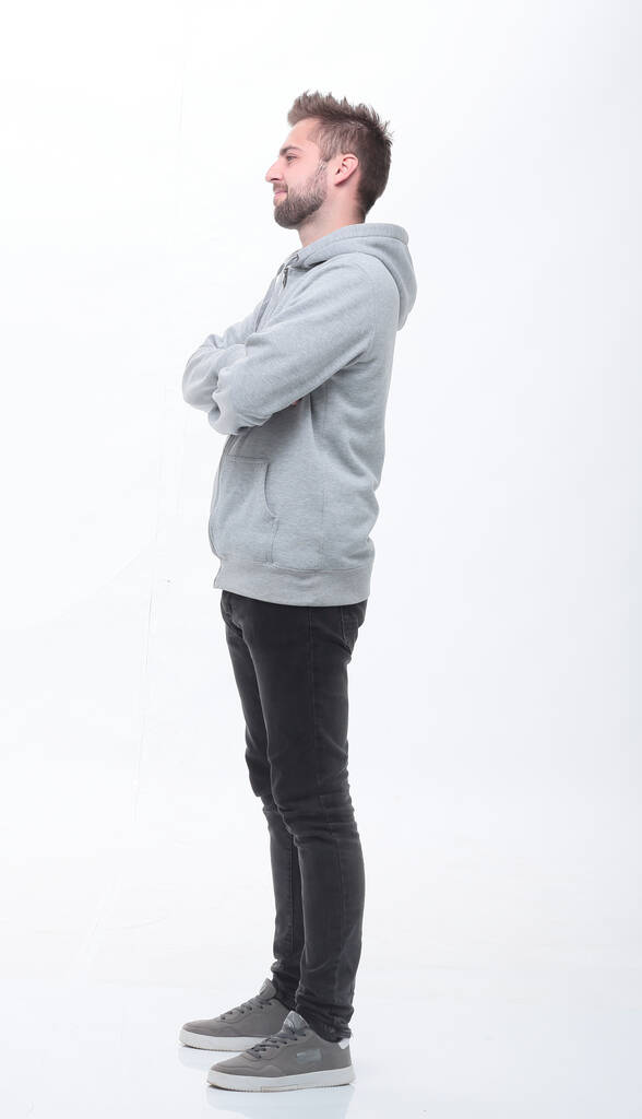 穿着时髦牛仔裤的年轻男子。在白色上隔离 穿着时髦牛仔裤的年轻男子。在白色上隔离