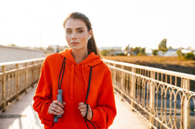 一個(gè)漂亮的健康女人帶著跳繩站在戶外的形象