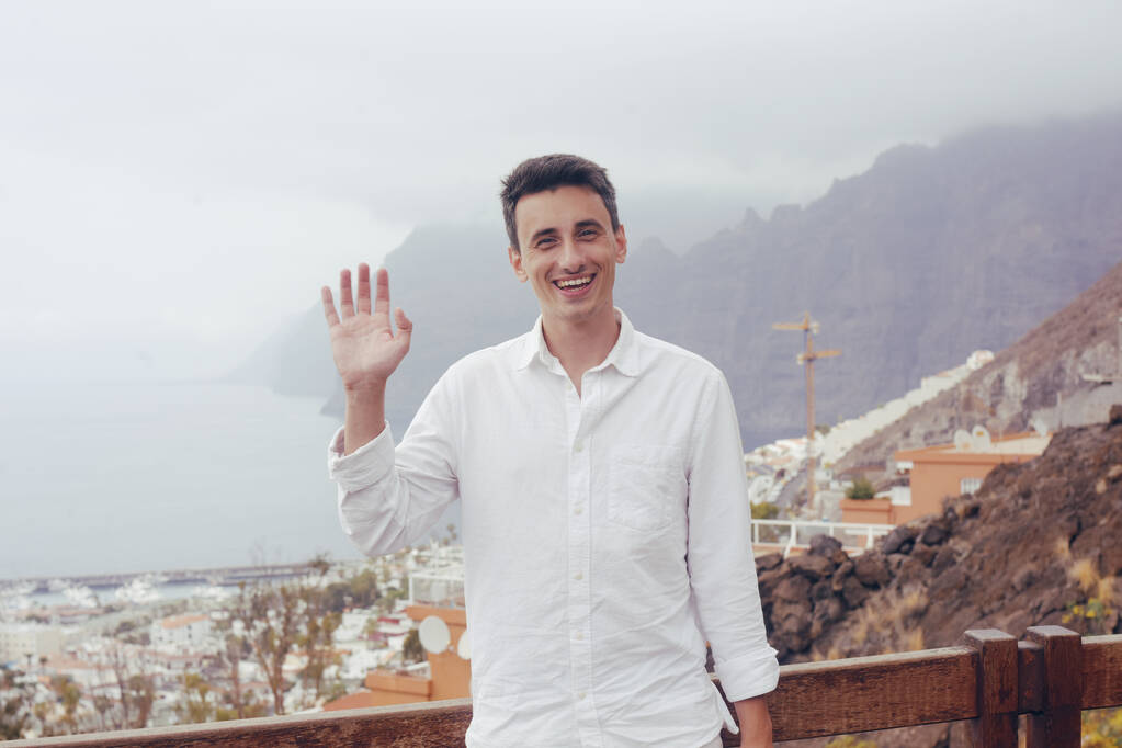 一个人在山区和城市的背景上。一个人在特内里费旅行。一个人在夏天学习世界。旅途愉快 一个人在山区和城市的背景上。一个人在特内里费旅行。一个人在夏天学习世界。旅途愉快