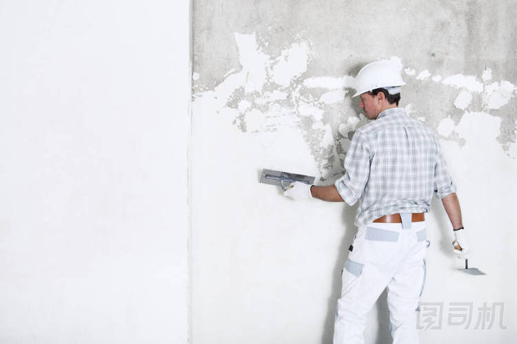 建筑工地內(nèi)墻上的大腸貼斑工頭戴安全帽和防護(hù)手套，隔離并復(fù)制白墻上的空間