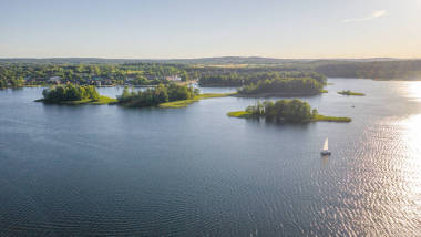 在陽(yáng)光明媚的夏日，從無(wú)人駕駛飛機(jī)飛往加爾夫湖的美麗全景航空?qǐng)D。在湖上有許多小船和游艇。在湖心有許多小島。)