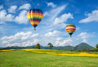 熱氣球在黃花場與山和藍色天空背景