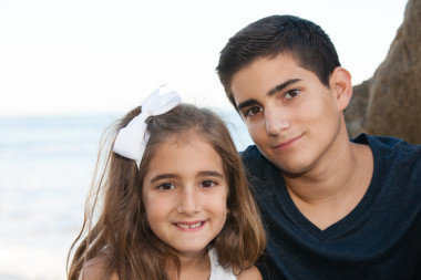 十幾歲的年齡段的男孩和他的妹妹在海邊合影