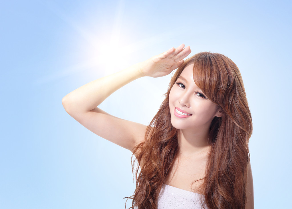 美丽的女人脸上的阳光和天空照片